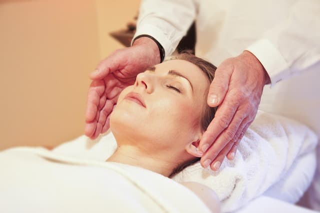 Hands hovering over a client, symbolizing energy healing